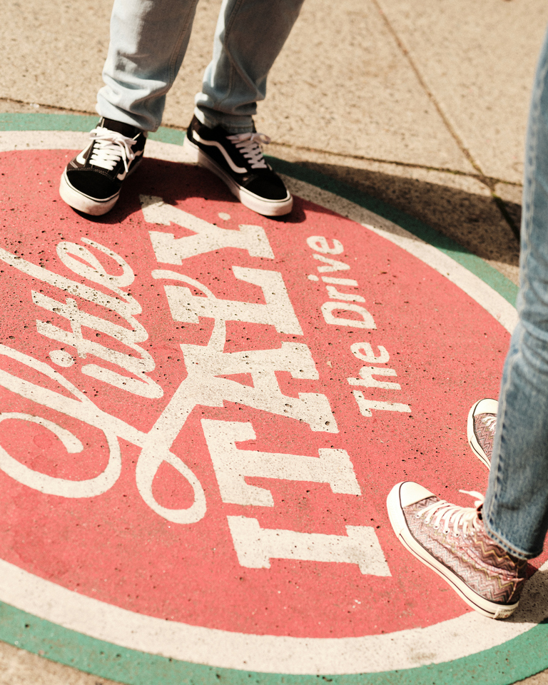 Sidewalk art at Little Italy The Drive, featuring colorful circle with people standing nearby.